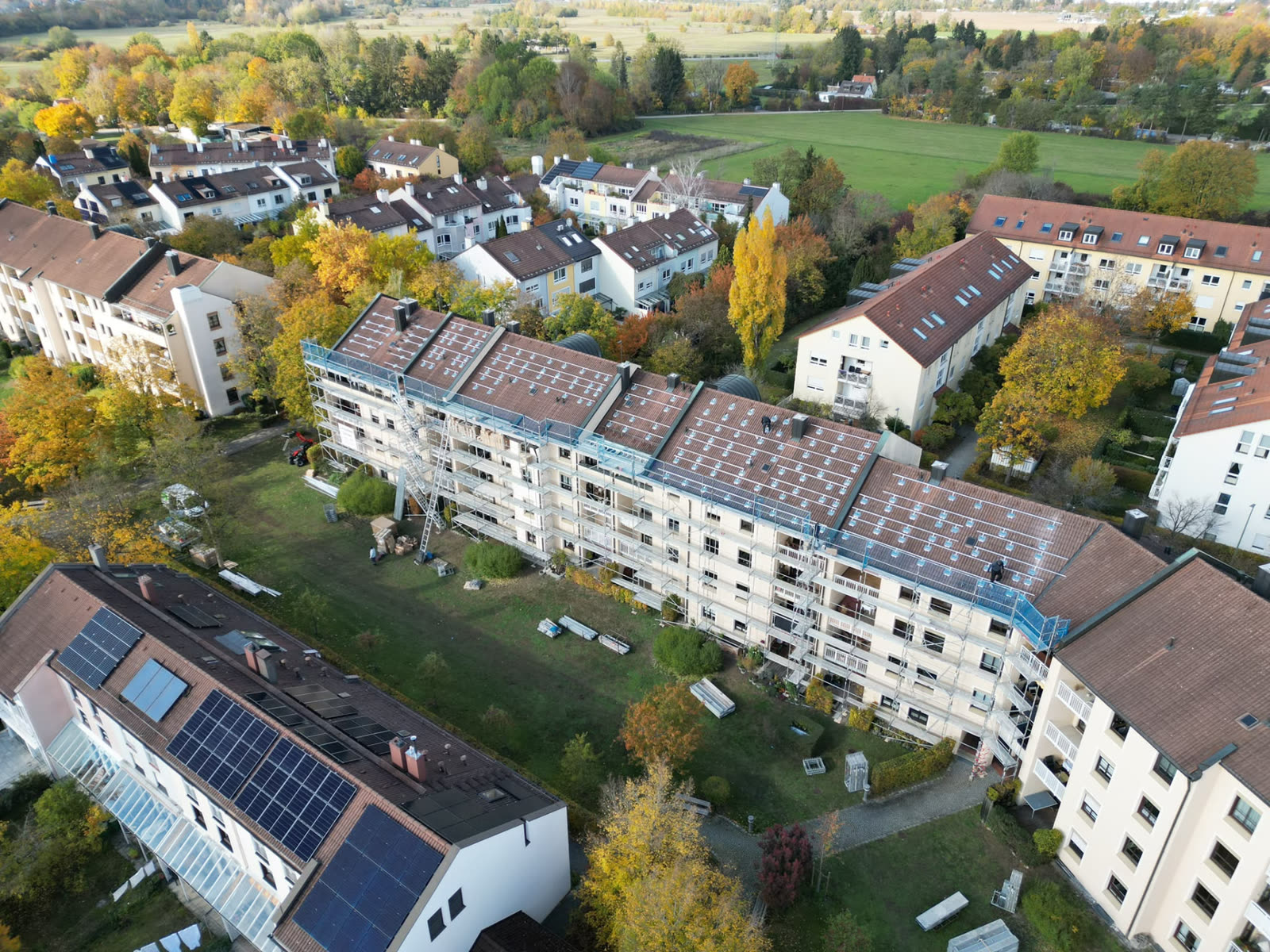 Drohnenaufnahme: PV-Unterkonstruktion auf den roten Ziegeldächern eines Wohnkomplexes in der Jaspersallee in München
