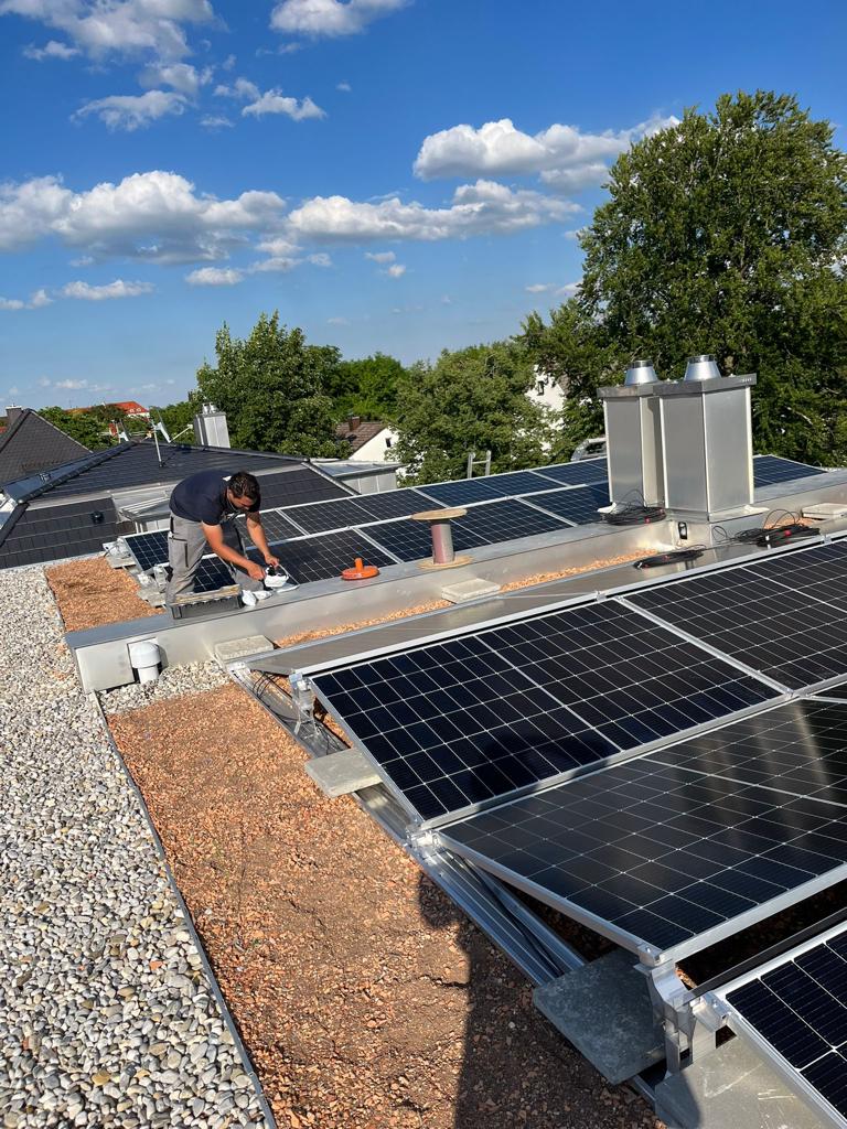 Monteur bei der Installation einer PV-Anlage auf Flachdach