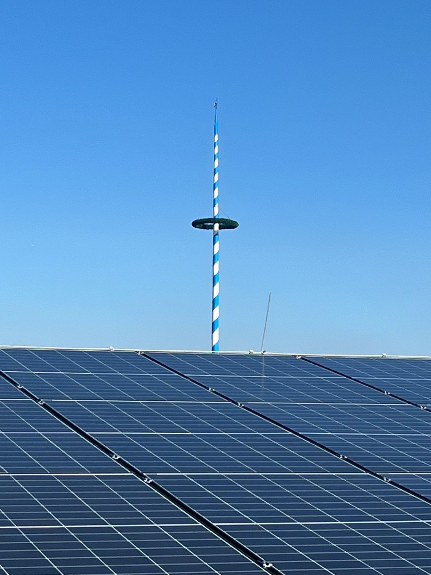 PV-Anlage mit bayerischem Maibaum im Hintergrund