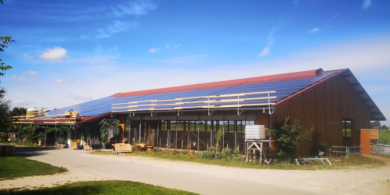 Großflächige PV-Anlage auf landwirtschaftlichem Gebäude während der Installation