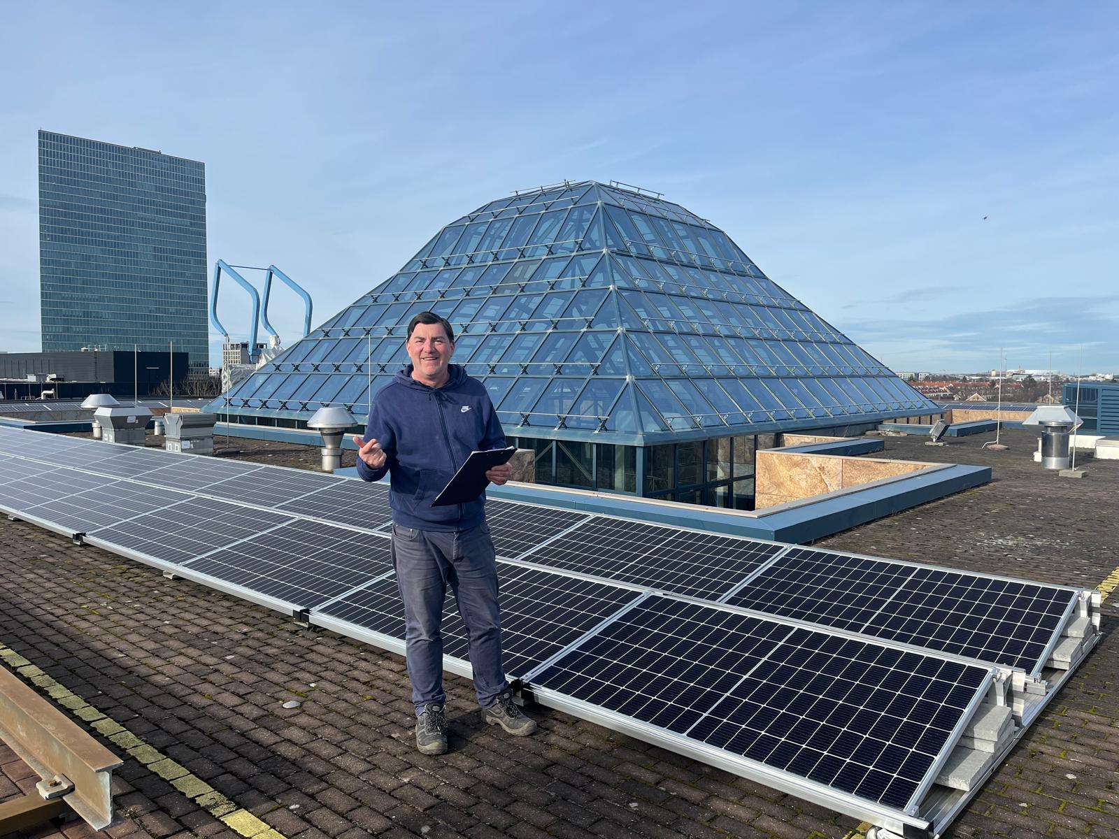 KW-Mitarbeiter vor PV-Anlage mit Glaspyramide in München