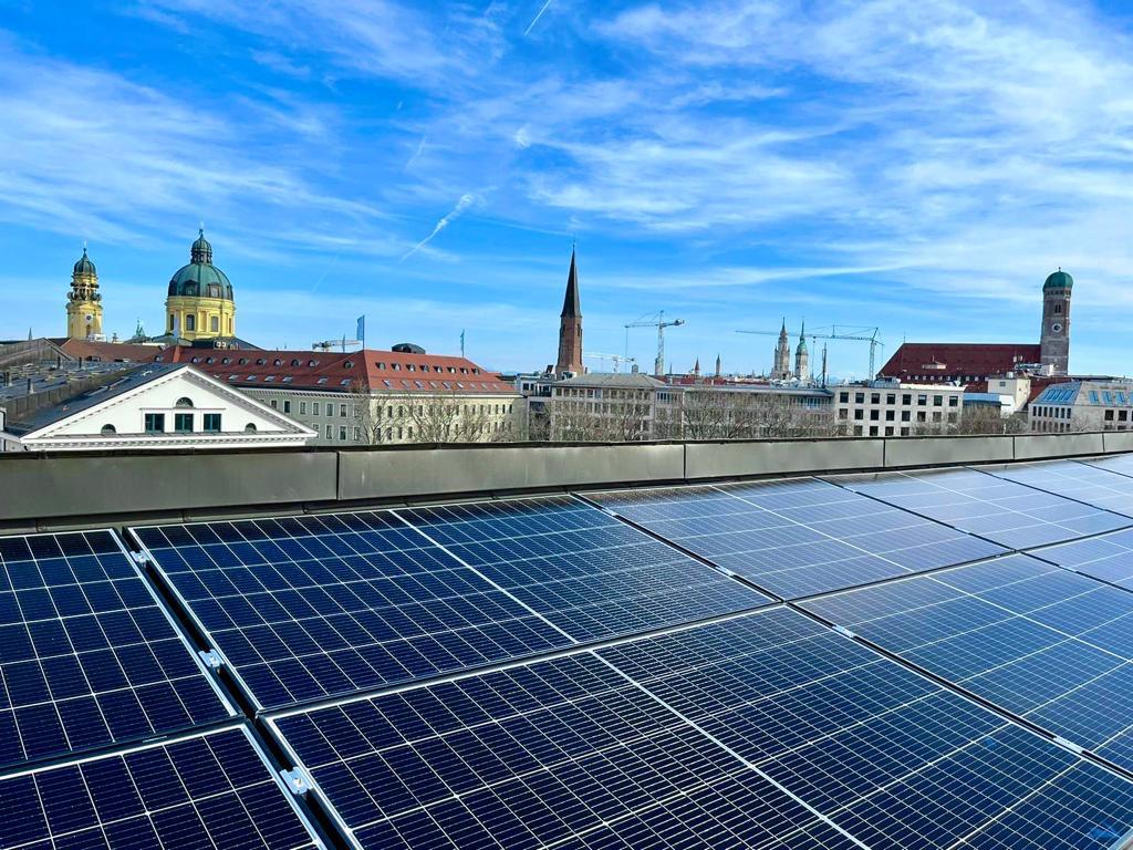 PV-Anlage auf Münchner Dach mit Blick auf Theatinerkirche und Frauenkirche